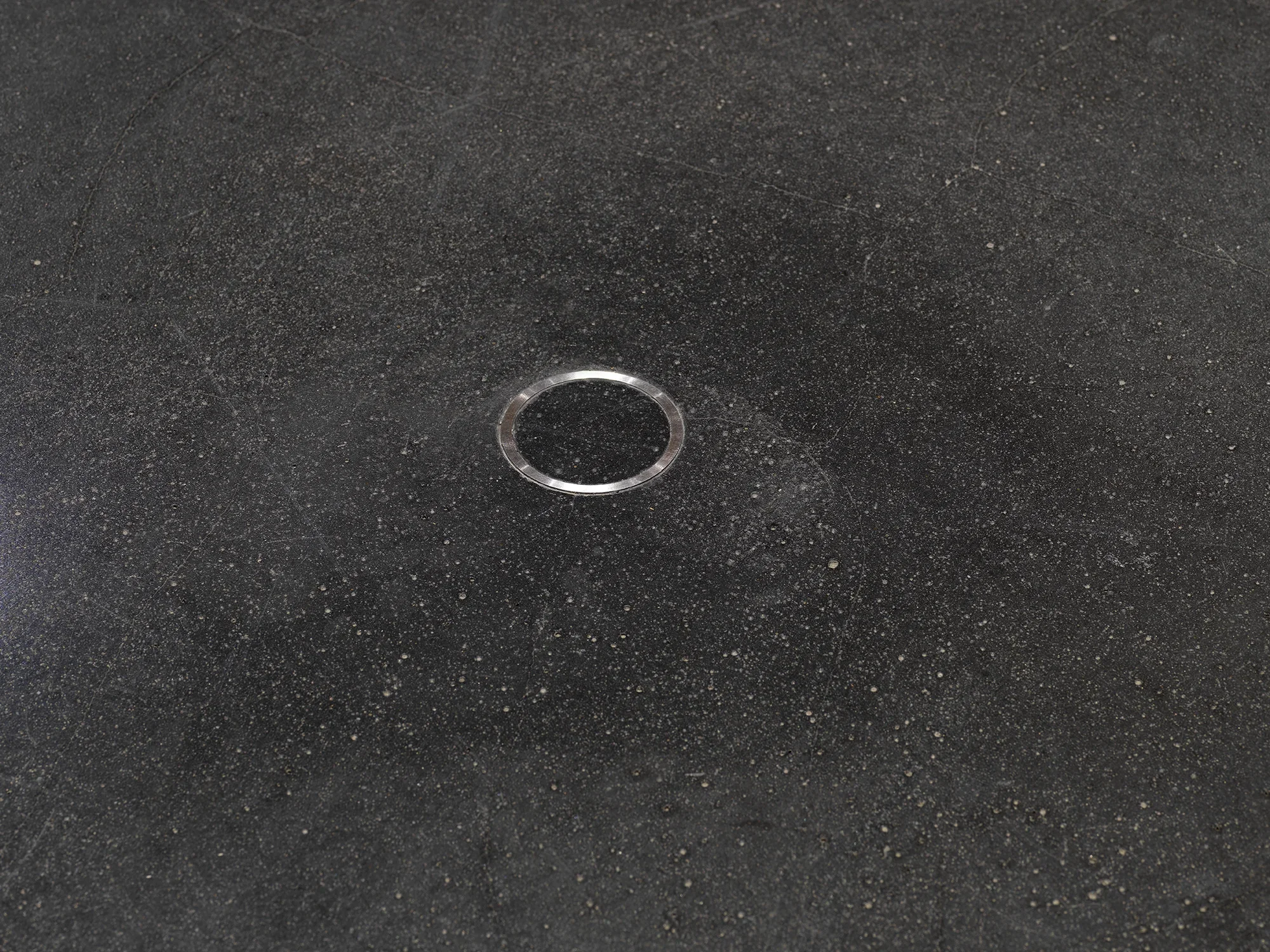 A small metal ring is cemented into the floor.