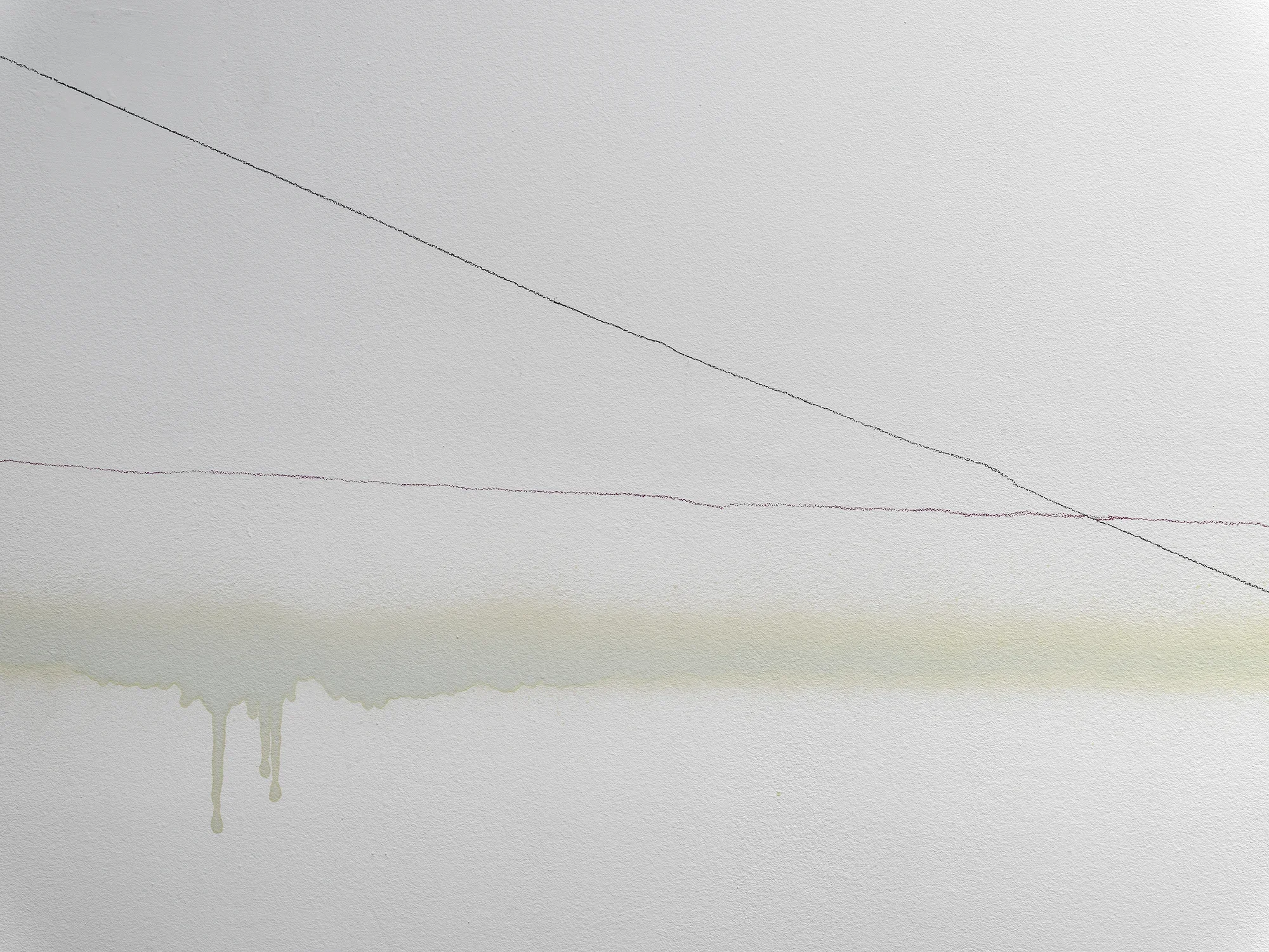 A close-up image of a white wall with lines traveling from left to right, like a comparison line graph. One line fluctuates around a consistent position, while another travels downward, intersecting the other near the image’s right edge. A more diffuse horizontal band of brown-gray color marks the wall horizontally; in one place, its lower edge bleeds down in a few darker drips.