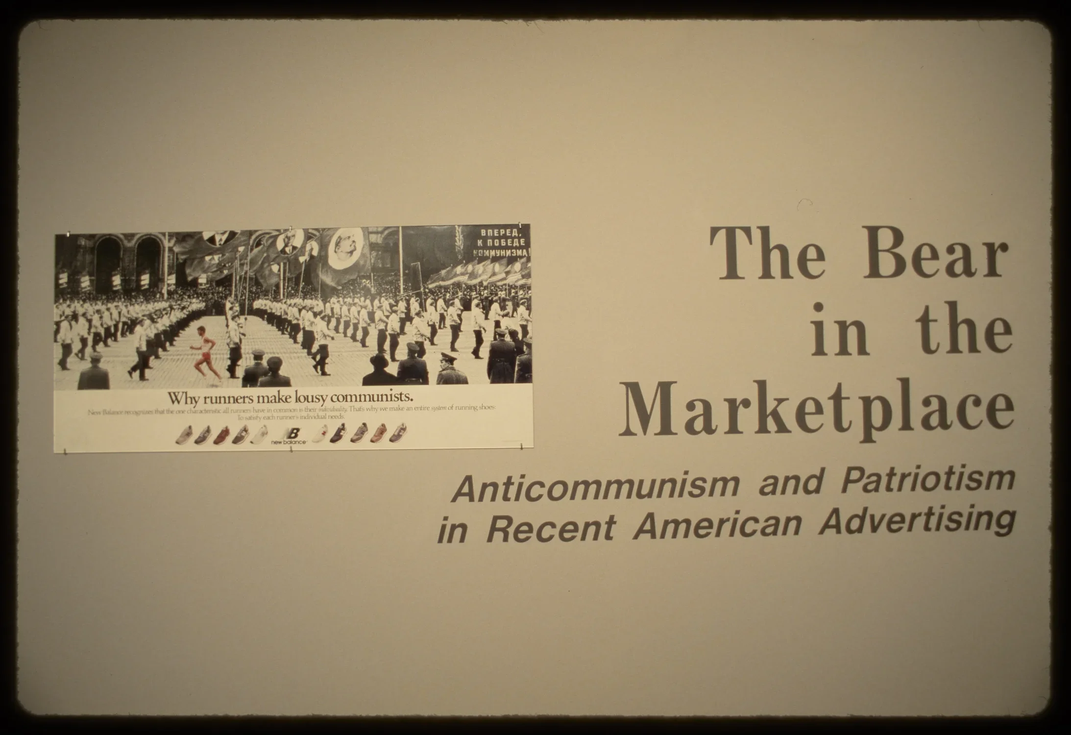 A wall of the exhibition with the title and advertisement for New Balance shoes stating, “Why runners make lousy communists.”