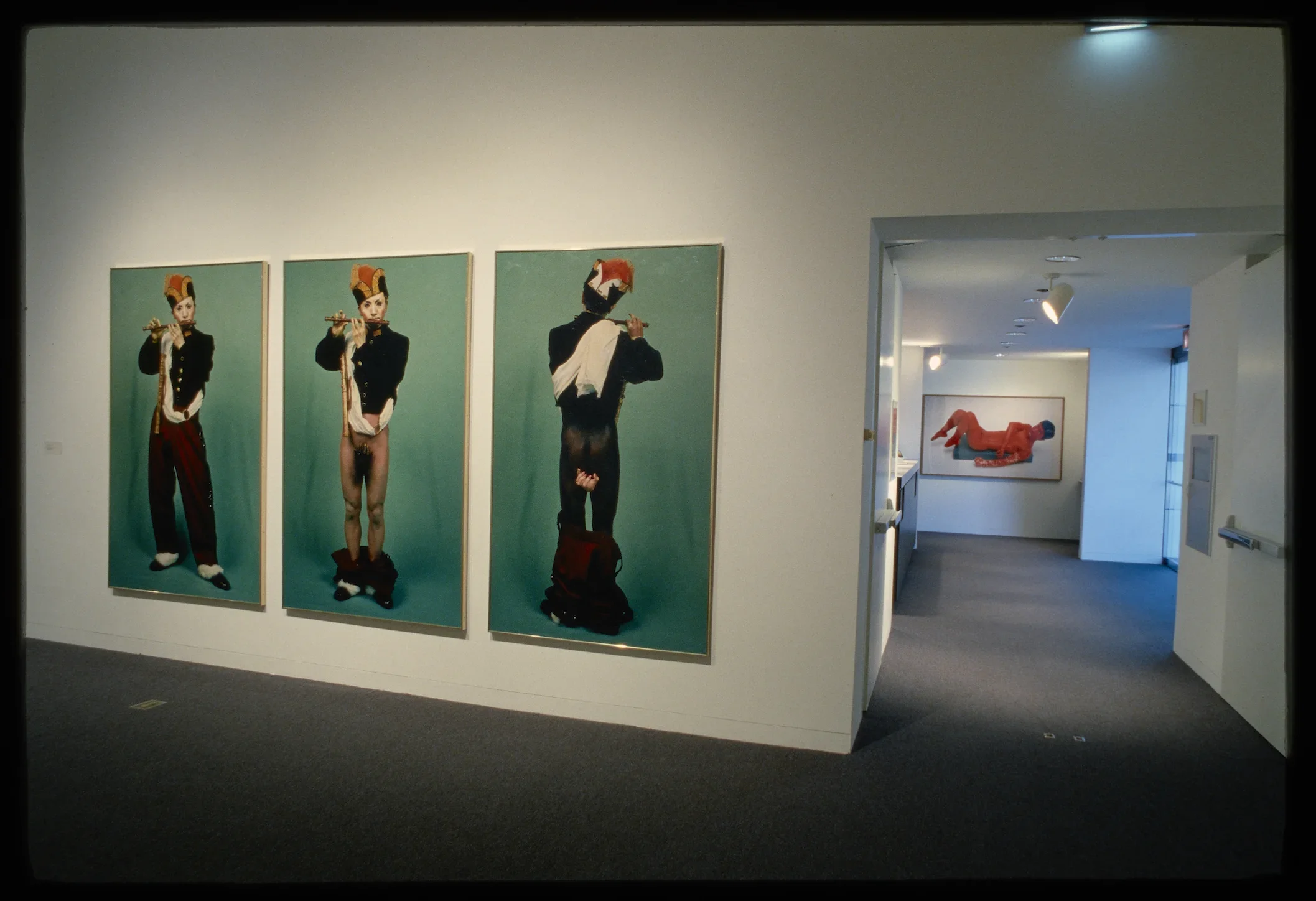 A 3 panel artwork shows a uniformed flute player with his pants lowered exposing his legs as white in one and black in another.