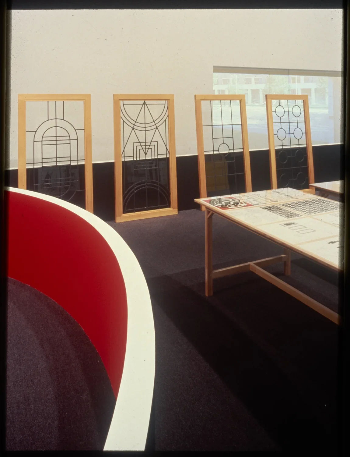 Large frames display metal geometric patterns as they lean against the short gallery walls. 