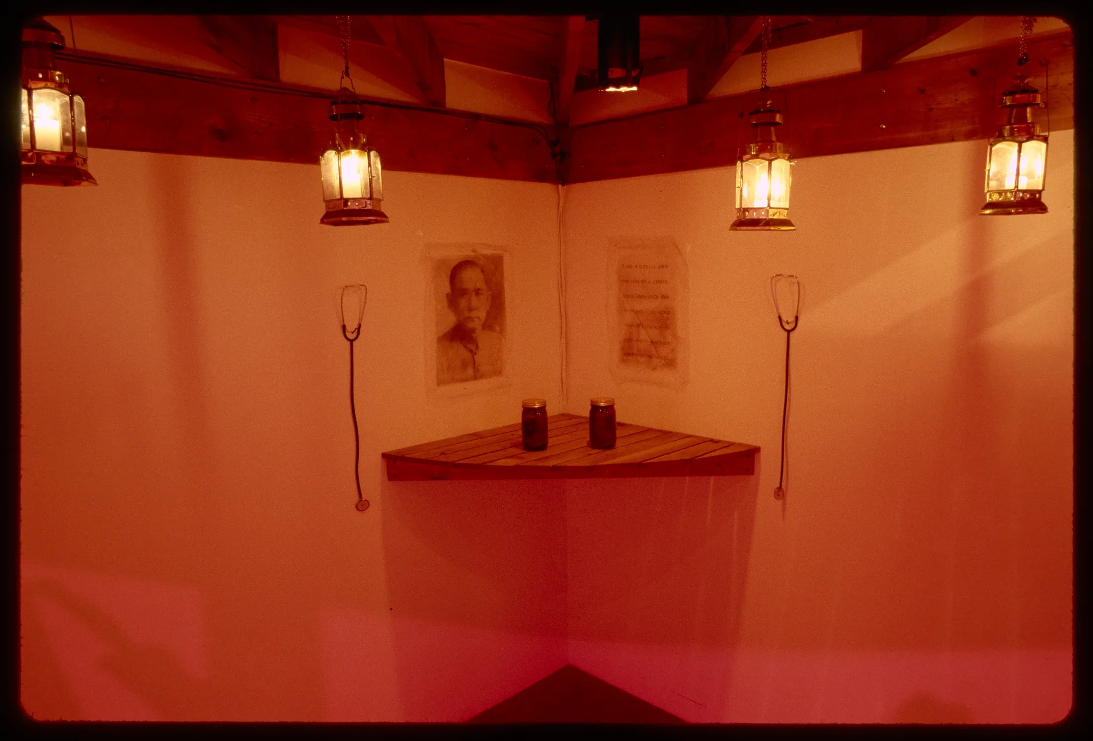 A surface juts from the corner holding two jars. On the wall are stethoscopes, an image of a Chinese man, and a letter.