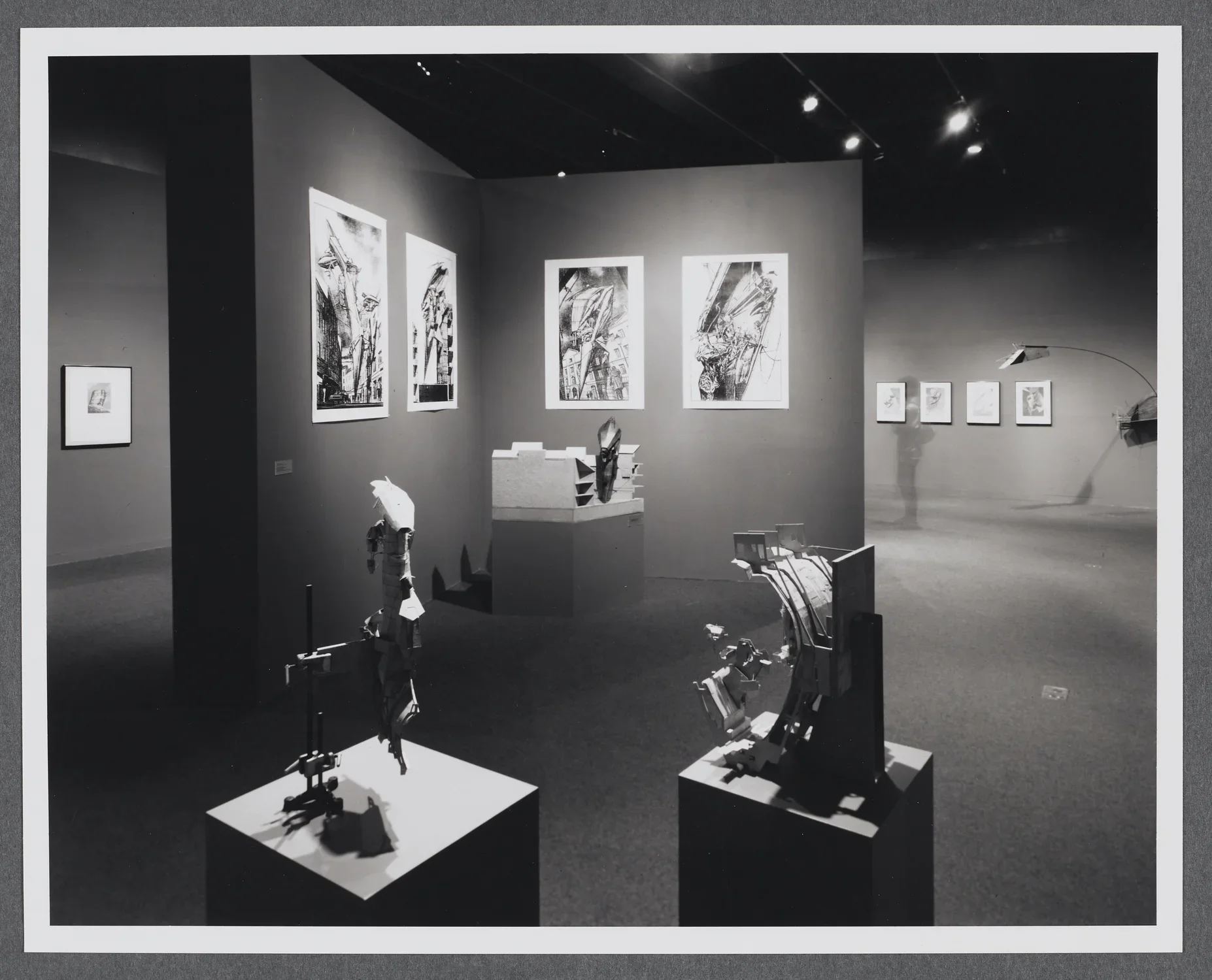 3D models sit on pedestals around the gallery. Large scale drawings hang on the gallery walls alongside the models. 