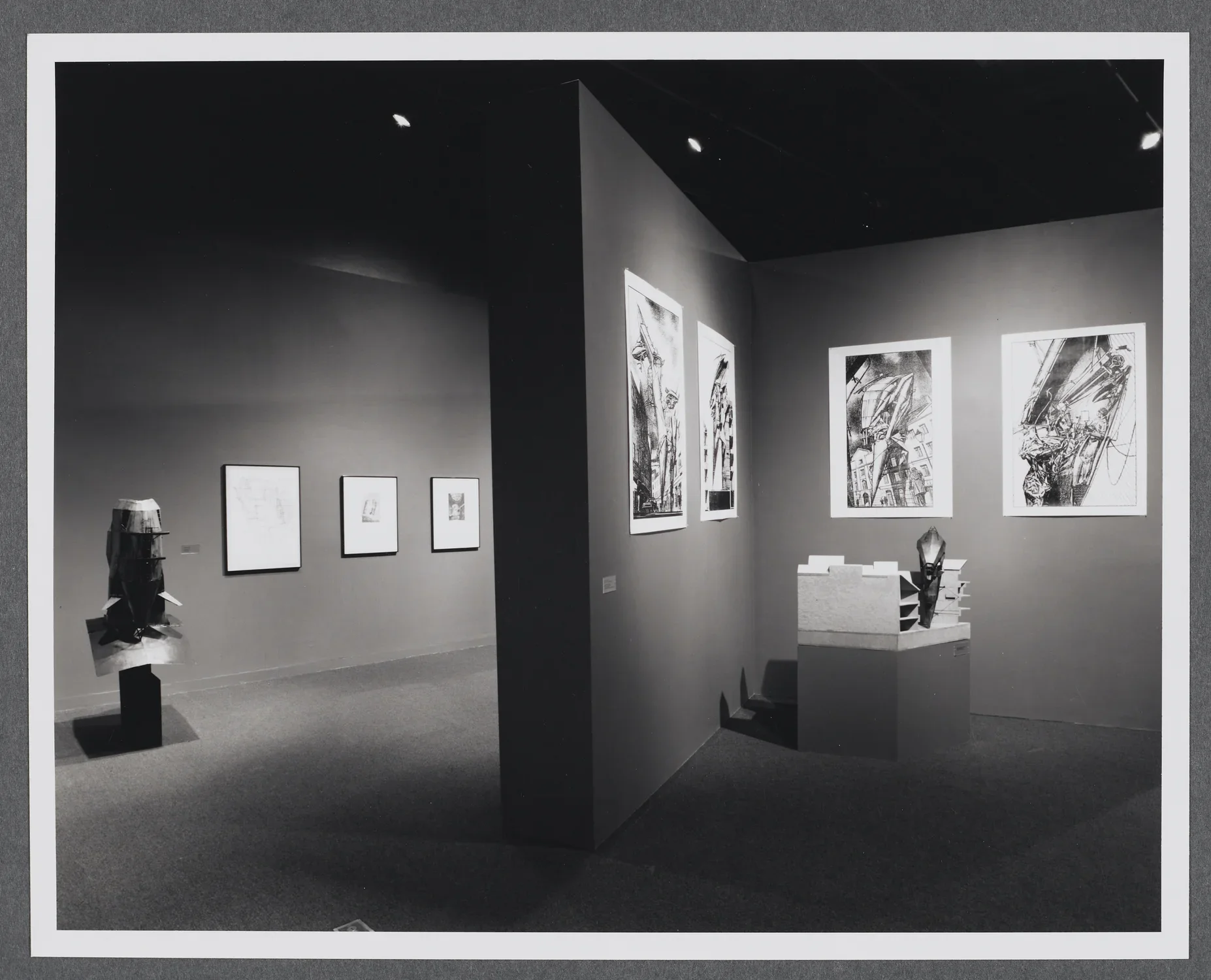 3D models sit on pedestals around the gallery. Large scale drawings hang on the gallery walls alongside the models. 