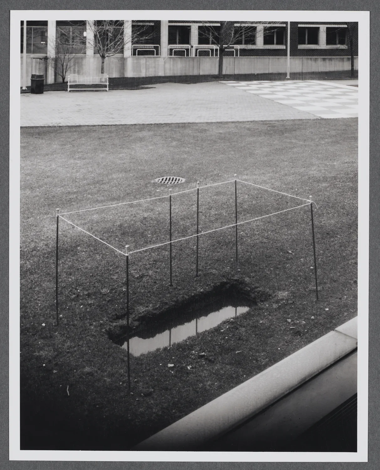 A rectangle has been dug into the ground and filled with water outside of the gallery.