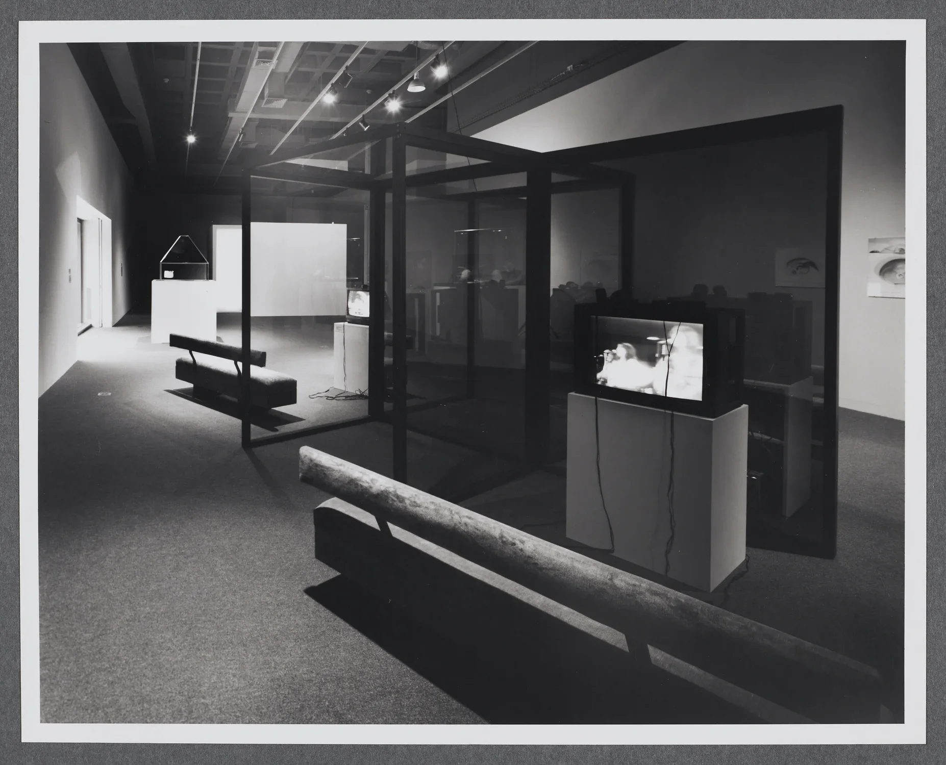 An installation using glass and mirror structures, video, and architectural models in the Hayden gallery of the List Center.