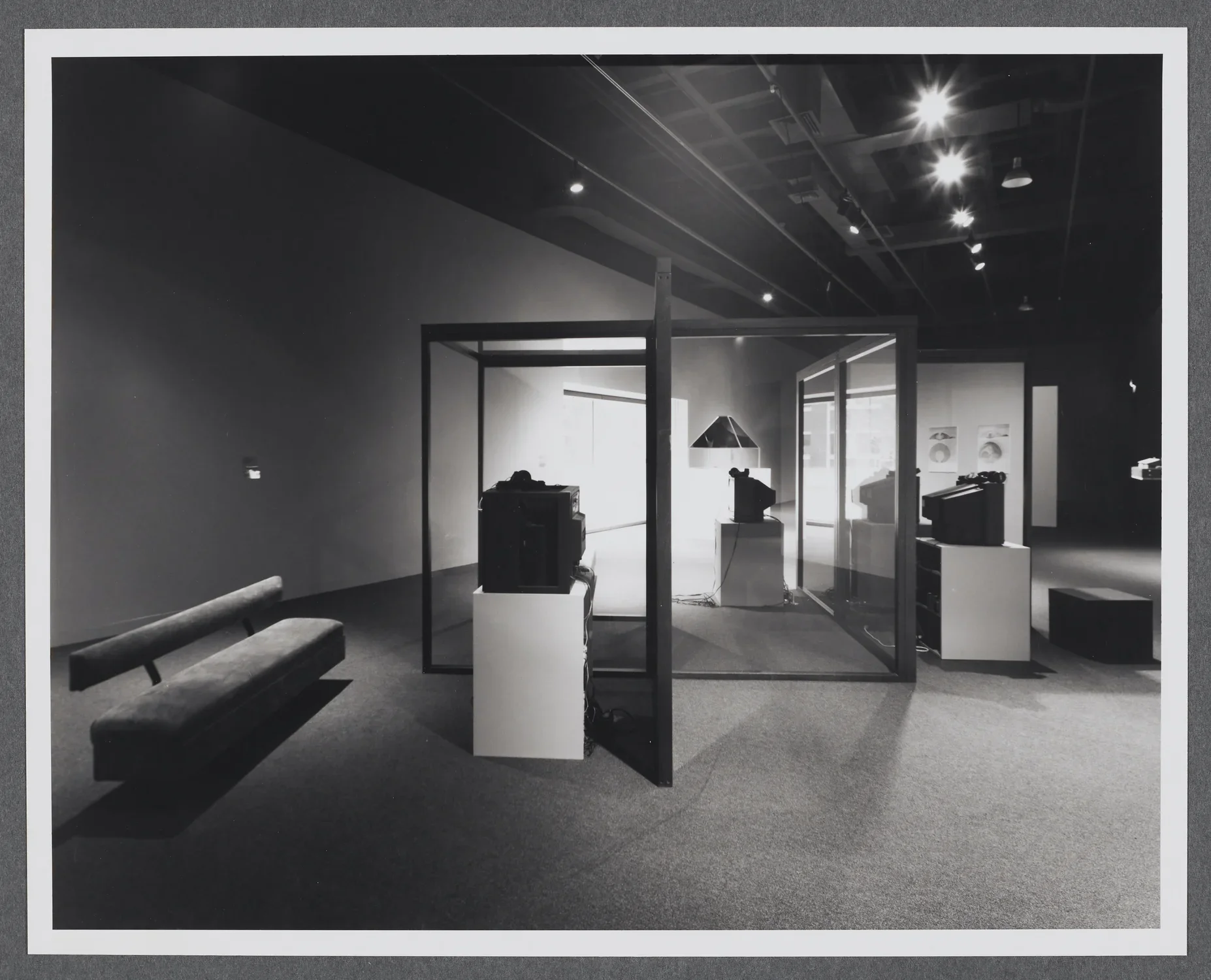 An installation using glass and mirror structures, video, and architectural models in the Hayden gallery of the List Center.