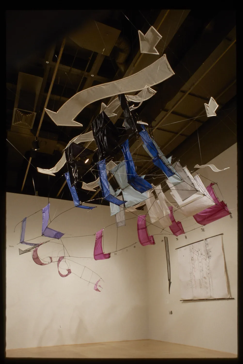 Large flying kite installed in a gallery made of colorful banners.