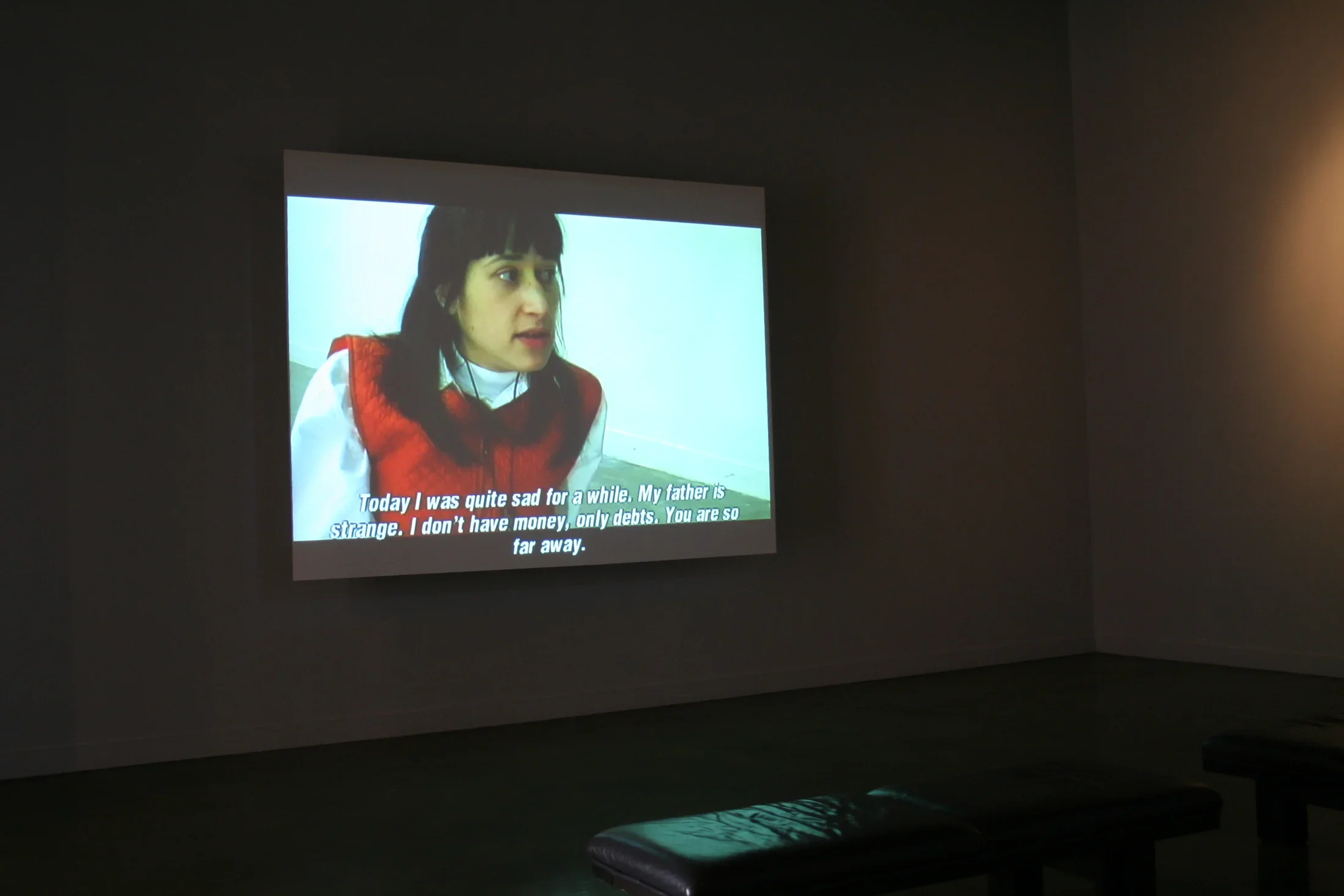 Projection of a woman with a red dress. Caption reads "Today I was quite sad for awhile. My father is strange..."