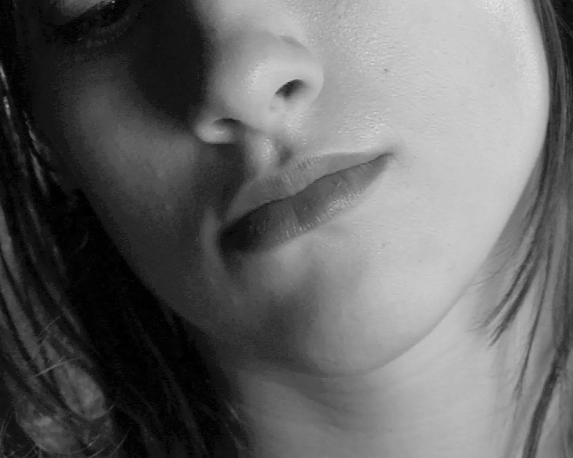 Very close zoom in of a woman's face from the neck to just above the nose. 