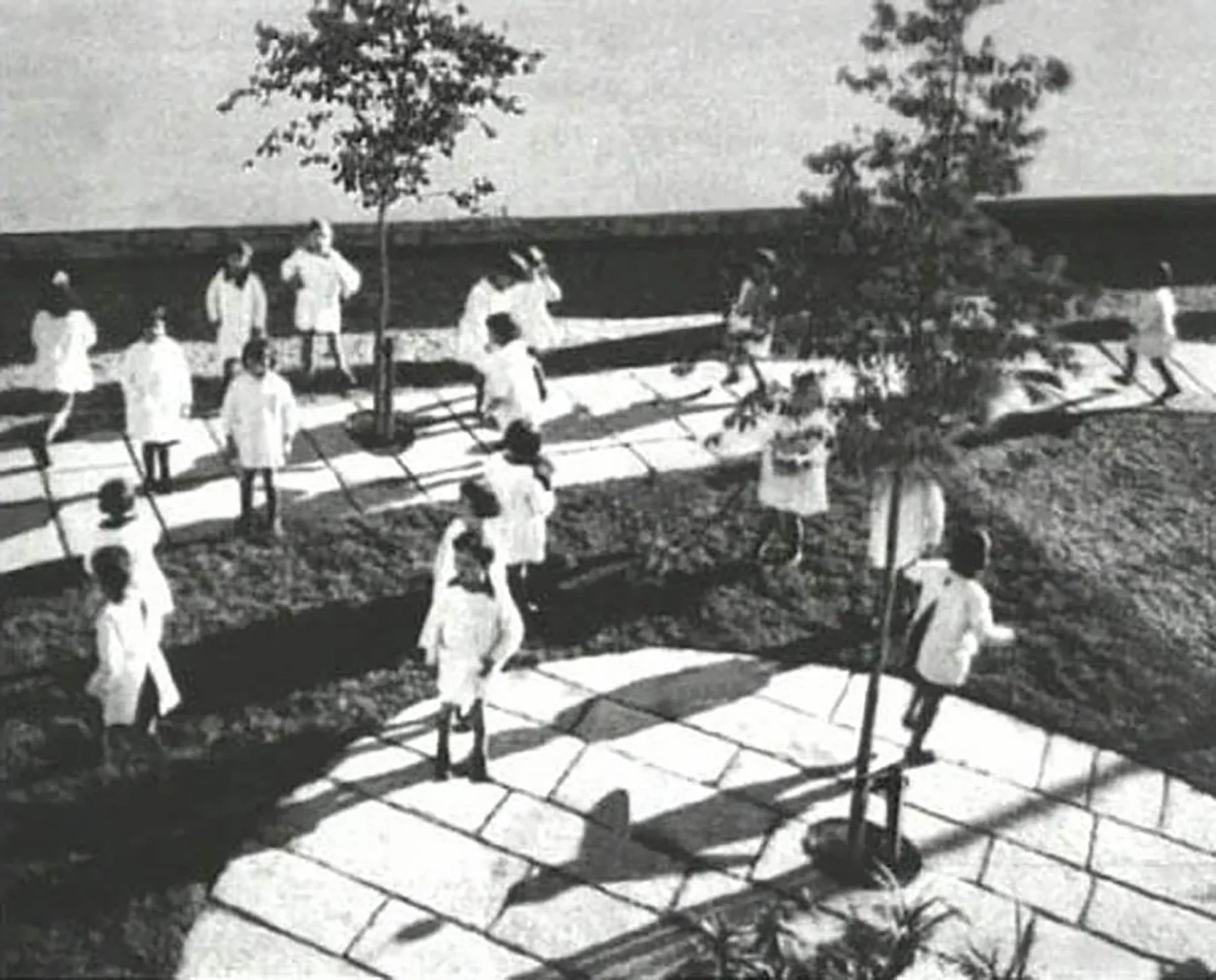 Students in uniform outside in a courtayard seemingly at recess. 