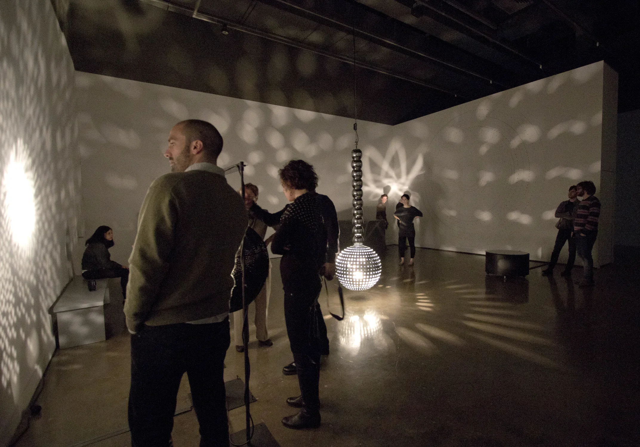 Viewers looking at the works in a gallery.