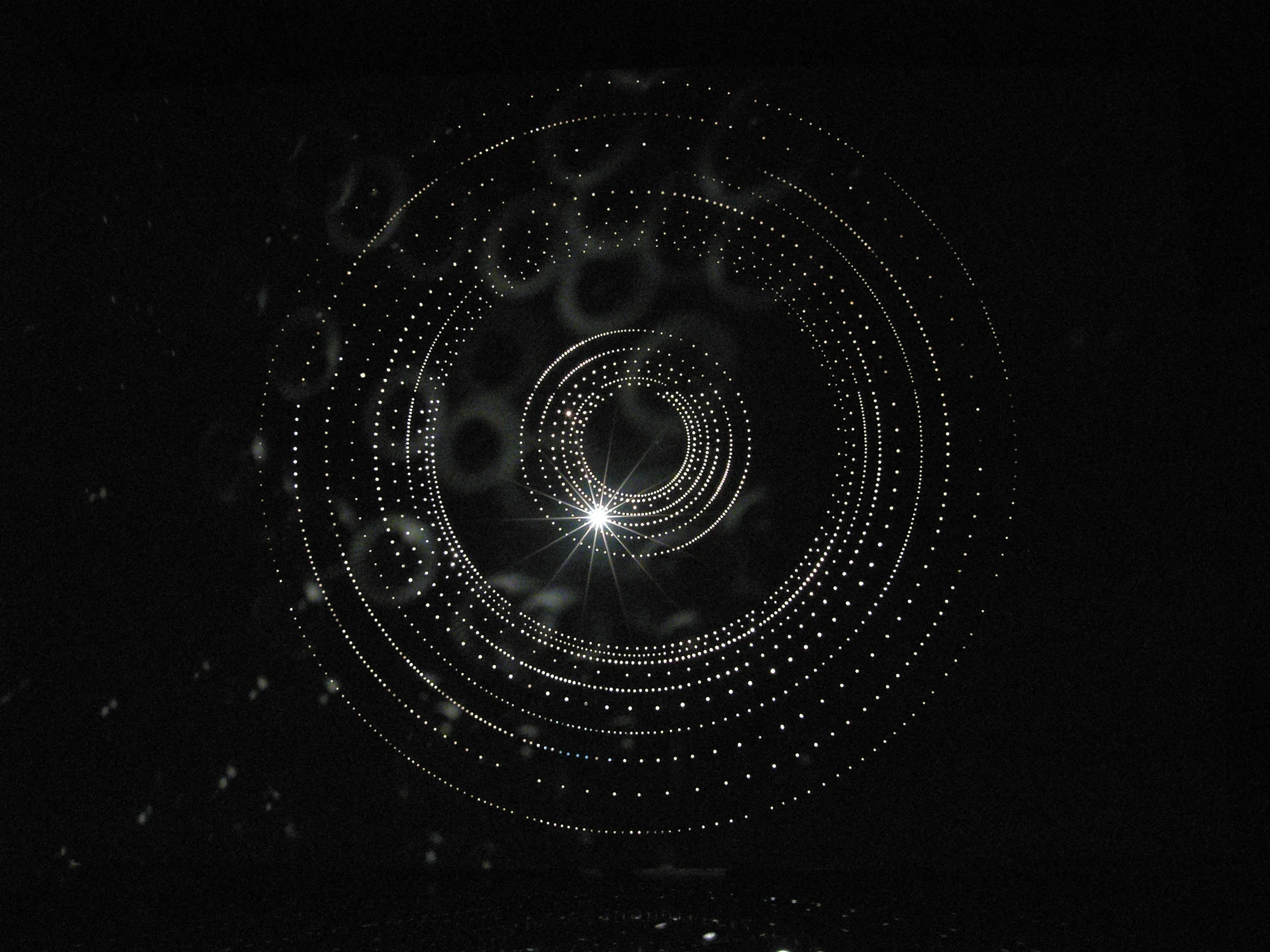 Small Lights installed in a circular motion on a black wall.