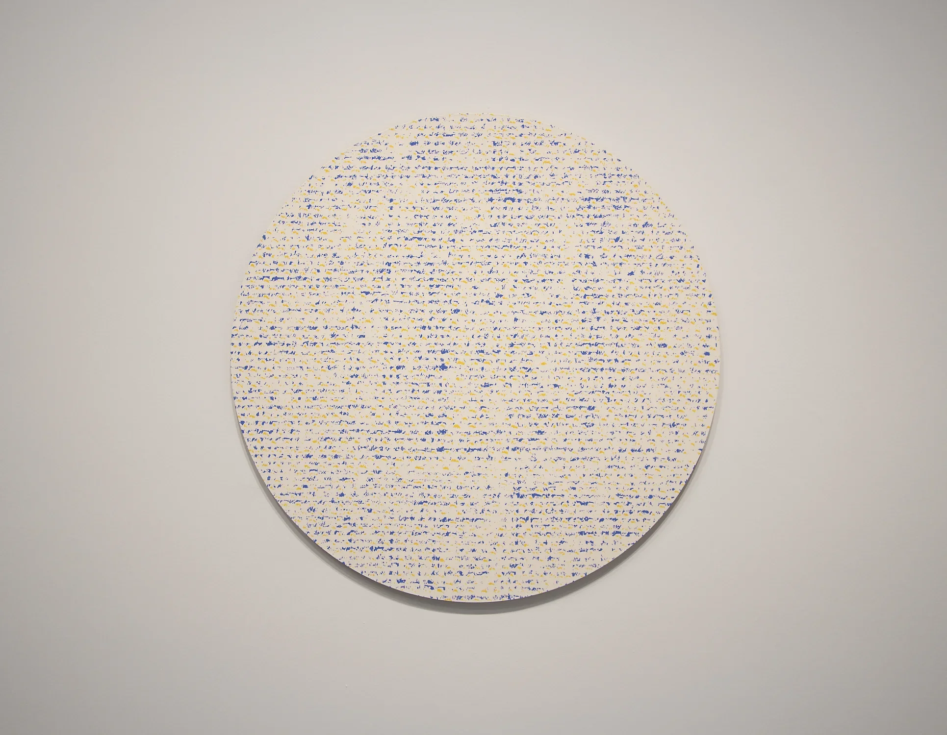 Round abstract painting of very small and tight polka dots. 