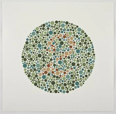 Small dots in various sizes and shades of blue and green create a circle. Hidden within is the number 2, written in orange dots