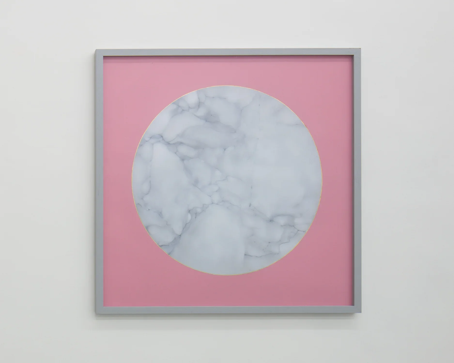 Gray square frame surrounds a painting of a circle of white veined marble, outlined with gold leaf on pink paper.