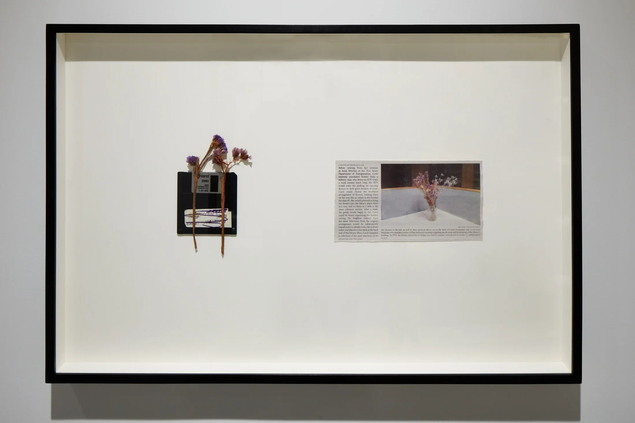 An artwork by Rose Salane features dried flowers on a memory card and a newspaper clipping.