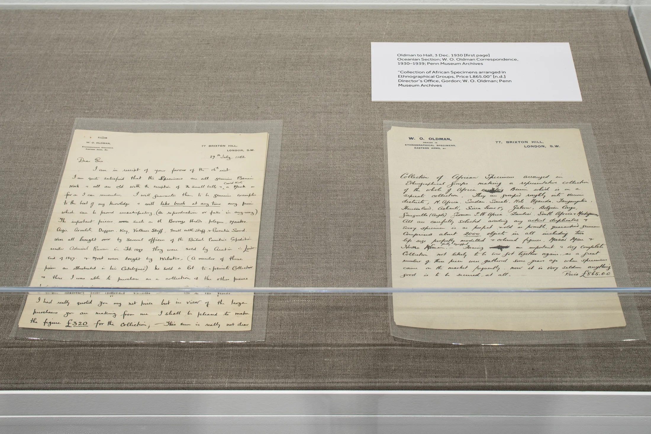 Letters from the year 1930 sit face up in a glass vitrine. The text is ornate cursive. 