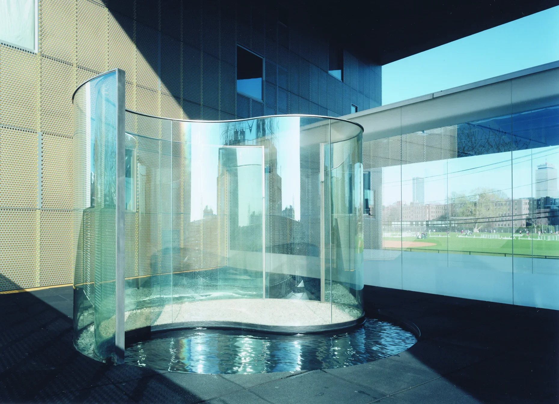 Tempered glass sculpture inside a building resembling a yin/yang symbol.