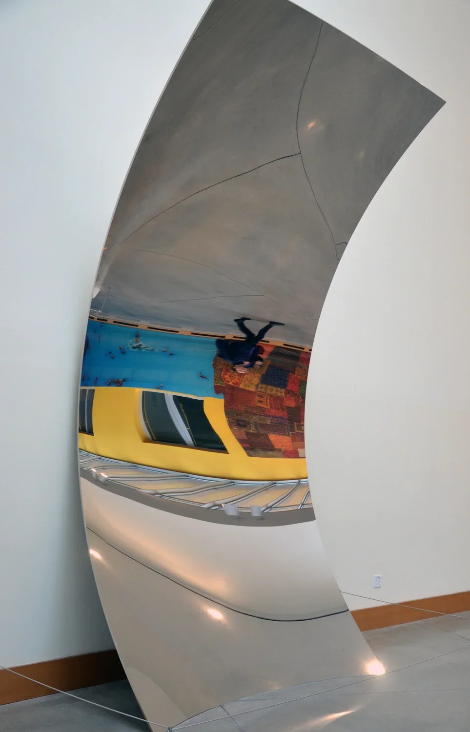 Monumental concave form which contrasts from the delicate structure, a thin sheet of mirror-polished stainless steel