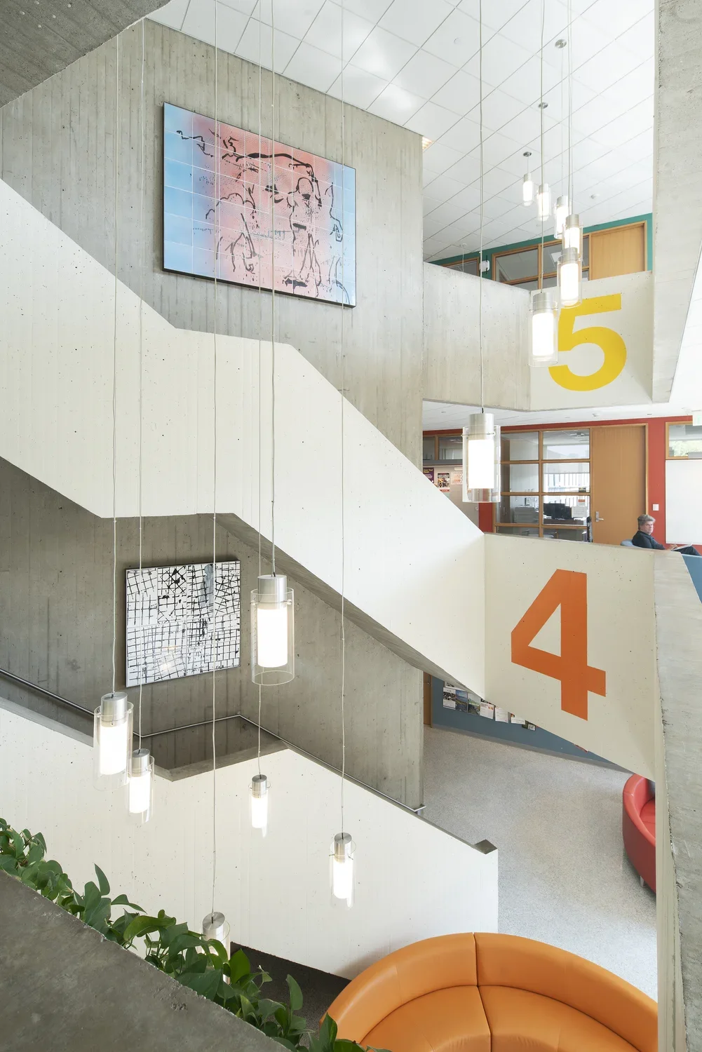 Stairwell with hanging lights and a tin-glazed hand-painted ceramic mural on the wall behind.
