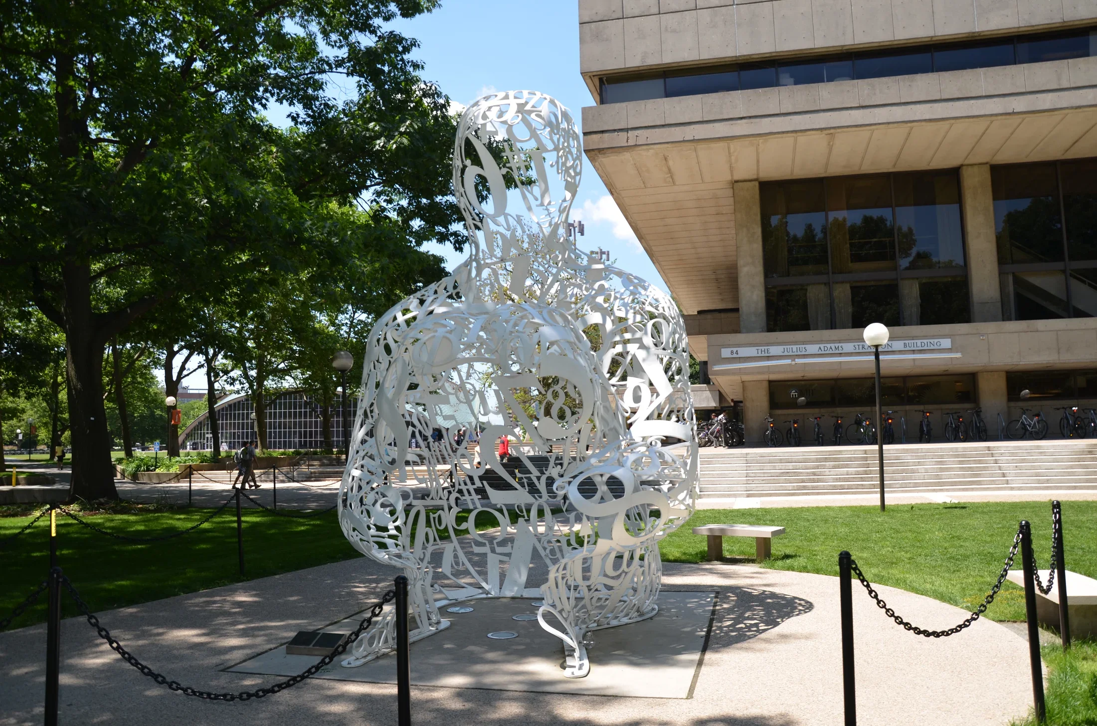 Sculpture made of tainless steel, white enamel paint featuring collages of letters, numbers, or symbols that appear to be in the process of organization.