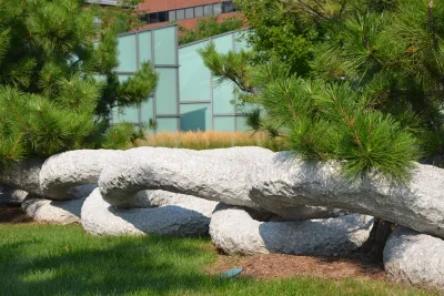 Large ranite ring sculpture surrounds the base of trees.