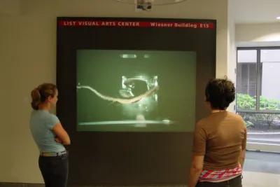 Two people look at a film projector screen