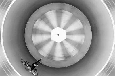 Film still of someone riding a bike in a circle.