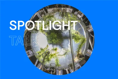 Blue background with text in white that reads &quot;Spotlight Talk&quot; and a circular image in the center of a glass sphere with green plants growing inside.