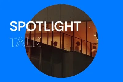 Black background with white text that reads &quot;Spotlight Talk&quot; in all uppercase letters. There is a circular image in the center that looks through windows on the Brutalist façade of Renzo Piano-designed [building], where visitors move through orange-hued galleries.