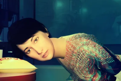 An animated video still of a seated figure with short black hair and wearing a glowing microcircuit patterned shirt rests their head on a laminate table near a bag of yellow Lays potato chips and plastic cup labeled “gpt2.”