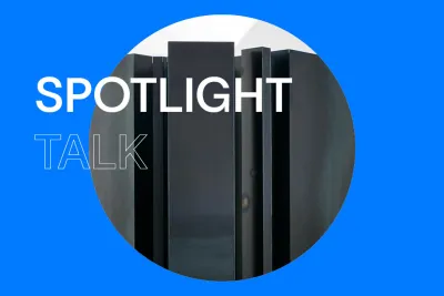 Bright blue background with white text that reads &quot;Spotlight Talk.&quot; In the center, there is a round close-up image of a dark steel sculpture.