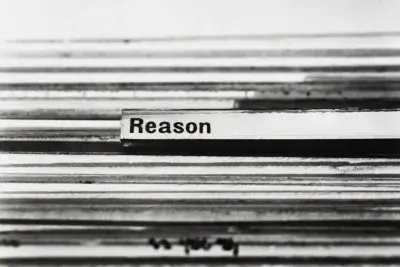 Detail image of many file folders in a row. There is one label tab highlighted with black bolded text. The text reads "Reason"