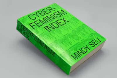 Bright green book on an angle. The front cover has black text that reads &quot;CYBER-FEMINISM INDEX. MINDY SEU&quot;