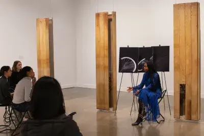 MIT graduate student sits presenting a talk to an audience of four people.