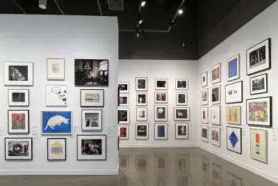 Installation view with framed artworks lining the walls floor to ceiling.