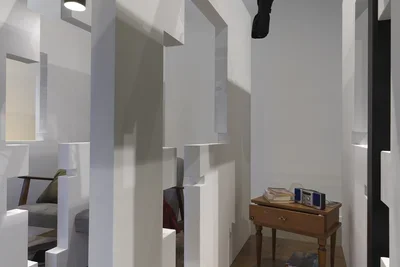 A series of fragmented white walls divides a living space with wooden floors, furniture, and house plants throughout. A wooden nightstand with a stereo and a stack of books is at the center of the frame. Each section of wall is connected by black beams.