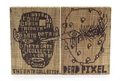 Two rectangular wooden panels, hinged together, display pixelated designs. The left panel features a head composed of words like 'DATA' and 'COLLECTOR,' with 'THE DATA COLLECTOR' written below. The right panel shows an abstract pixelated face with 'DEAD PIXEL' written below.