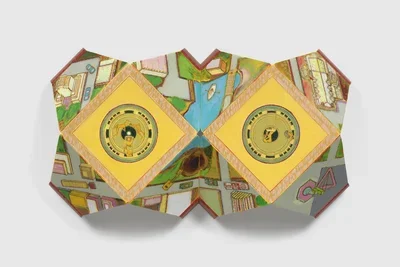 A multi-panel artwork, folded like an open book, features a painted landscape of greens and blues. Two prominent yellow square panels with corners facing up and down, each with an intricate circular design, are centered on the piece.