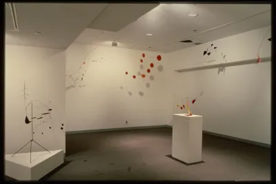 Mobiles both hang from the ceilings and sit upon pedestals. They balance geometric shapes in all different colors.