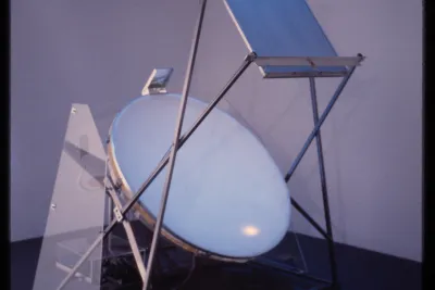 An apparatus made from a large disk angled up to a flat surface. Rods help to keep the disk and surface in place.