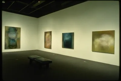 Abstracted paintings hang around the gallery. Each one is textured in a way where the colors are blended and vibrating.