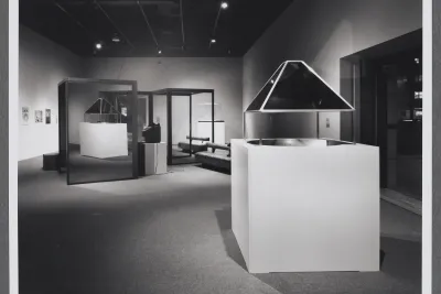 An installation using glass and mirror structures, video, and architectural models in the Hayden gallery of the List Center.