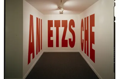 Large red block letters fill the walls of a spotlit alcove. The letters read ANI, ETZS, and CHE.