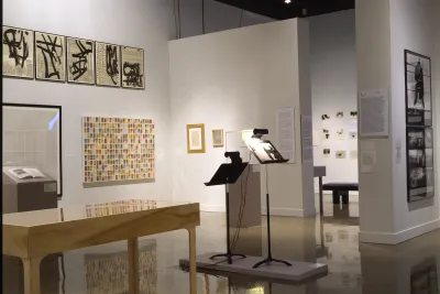 Artwork in various mediums and styles are spaced throughout the gallery on the walls, on stands, and in cases.