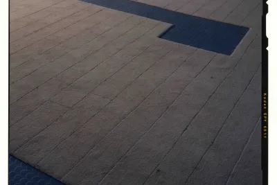 Shaved tan carpet with a long rectilinear cutout shows the dark rubber flooring underneath.