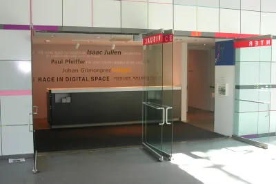 Entrance of the List gallery, glass doors open onto the wall listing the current artist shows.