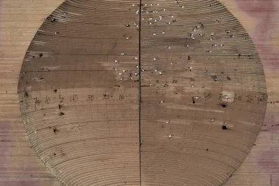 A concave wood sculpture reveals layers of wood and pencil marks.