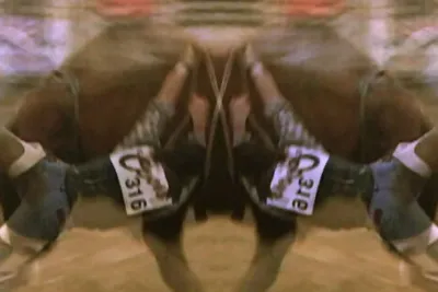A mirrored image of a cowboy wrestling with a bull. The image is mirrored in the center of the frame, creating a doubling effect.